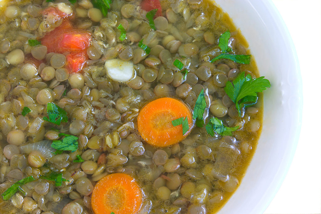 closeup of soup with lentil ,carrot,tomato,garlic and parsley